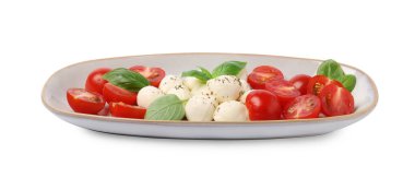 Domatesli, mozzarella, fesleğen ve baharatlı bir tabak lezzetli Caprese salatası.