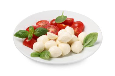 Bir tabak lezzetli Caprese salatası, domatesli, mozzarella ve fesleğenli beyaz.