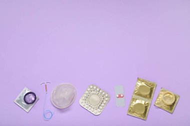 Doğum kontrol hapları, prezervatifler ve eflatun arkaplan üzerine rahim içi cihazlar, düz yatak ve metin için alan. Farklı doğum kontrol yöntemleri