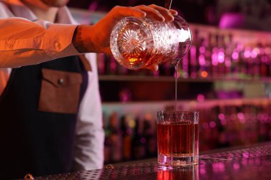 Barmen barda taze alkollü kokteyl hazırlıyor.