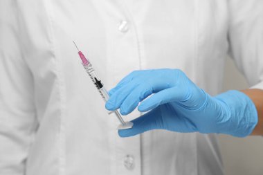 Şırıngayı elinde tutan doktor, yakın çekim.