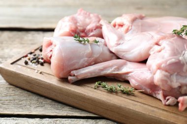 Taze çiğ tavşan eti ve baharatlar ahşap masada, yakın plan.