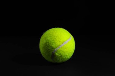Siyah arka planda parlak bir tenis topu