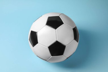 Açık mavi arka planda bir futbol topu. Spor malzemeleri.