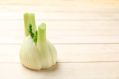 Hafif ahşap masada taze çiğ rezene ampulü, yakın plan. Metin için boşluk