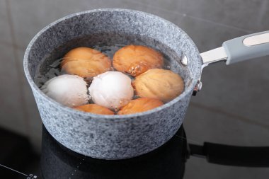 Elektrikli ocakta tavuklu yumurta kaynıyor, yakın plan.