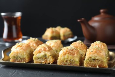Koyu dokulu masa üzerinde doğranmış fındıklı enfes taze baklava, yakın plan. Doğu tatlıları