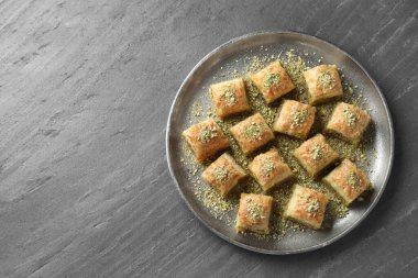 Gri masaya doğranmış fındıklı enfes taze baklava, üst manzara ve yazı için yer. Doğu tatlıları