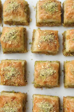 Beyaz masa üzerinde doğranmış fındıklı enfes taze baklava. Doğu tatlıları
