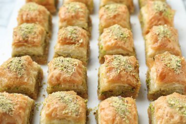 Beyaz masada doğranmış fındıklı enfes taze baklava, yakın plan. Doğu tatlıları