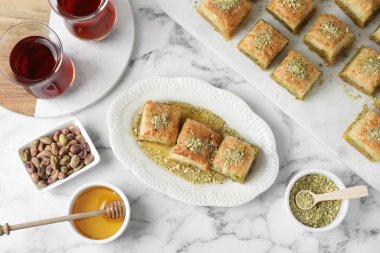 Beyaz mermer masada servis edilen fındıklı ve ballı enfes taze baklava. Doğu tatlıları