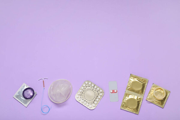 Противозачаточные таблетки, презервативы и внутриутробное устройство на сиреневом фоне, плоский уголок и пространство для текста. Различные методы контрацепции