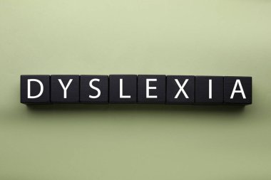 Zeytin zemininde kelime disleksisi olan tahta küpler, düz uzanma