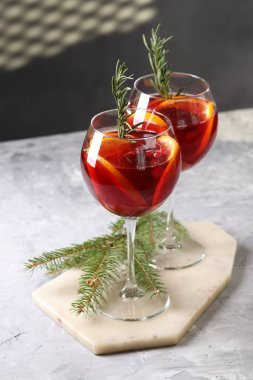 Gözlüklü Noel Sangria kokteyli ve gri desenli masada köknar ağacı dalı.