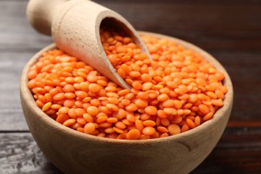 Çiğ kırmızı mercimek ve kepçeyle tahta masada, yakın plan.