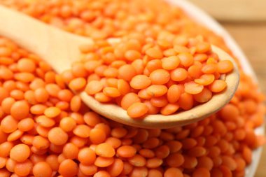 Çiğ kırmızı mercimek ve kaşık masada, yakın plan.