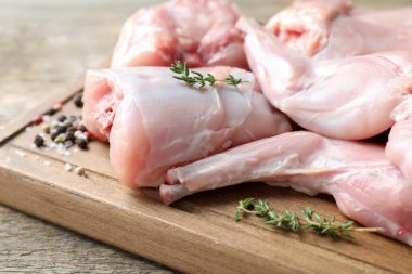 Taze çiğ tavşan eti ve baharatlar ahşap masada, yakın plan.