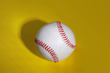 Sarı arka planda bir beyzbol topu, üst manzara.