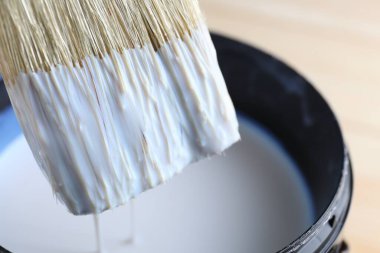 Fırçayı cila ile kutuya daldırıyorum, yakın plan.