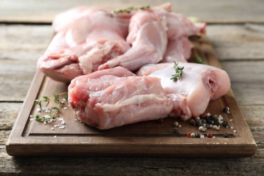 Taze çiğ tavşan eti ve baharatlar ahşap masada, yakın plan.