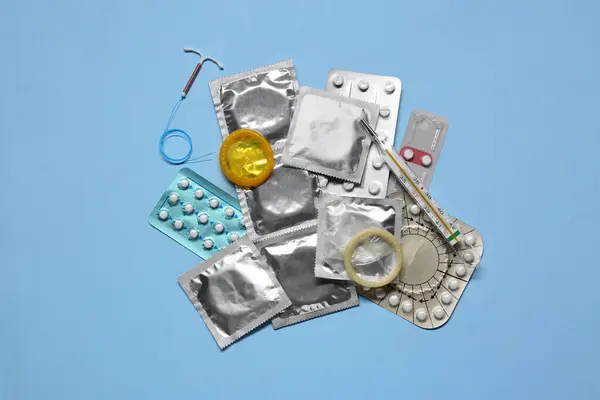 Pillole Contraccettive Preservativi Dispositivo Intrauterino Termometro Sfondo Azzurro Strato Piatto — Foto Stock