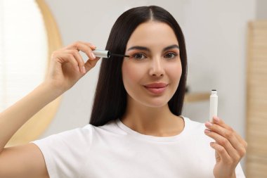 Kirpiklerine serum süren güzel bir kadın. Kozmetik ürünü