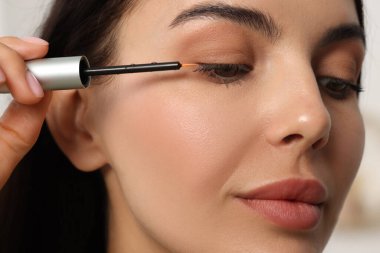 Kirpiklerine serum süren güzel bir kadın. Yakın plan. Kozmetik ürünü