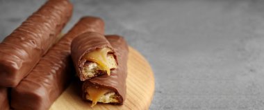 Gri masasında karamel olan tatlı, çikolatalı gofretler, yakın plan. Metin için alanı olan pankart tasarımı