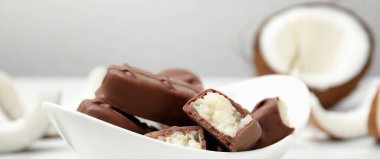 Beyaz masada hindistan cevizli çikolatalı çikolatalar, yakın plan. Pankart tasarımı