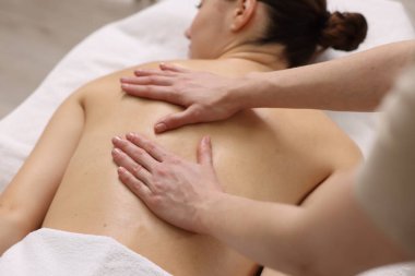Kaplıca salonundaki kanepede sırt masajı yaptıran kadın, yakın plan.