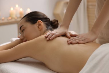 Spa salonundaki kanepede sırt masajı yaptıran kadın.