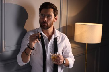 Evde puro içen yakışıklı bir adam.