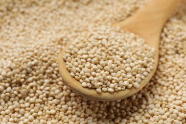 Ahşap kaşık ve ham kinoa arka plan olarak, yakın plan