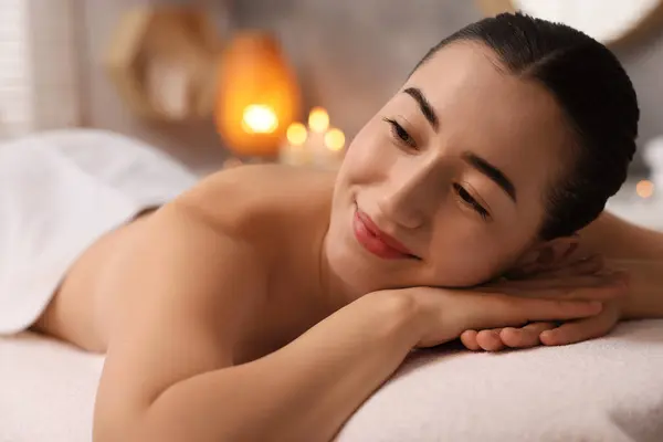 Beautiful woman relaxing on massage couch in spa salon