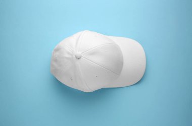 Açık mavi arka planda şık beyaz beysbol şapkası, üst görünüm