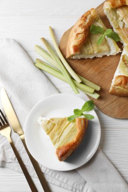 Taze pişmiş ravent turtası, saplar ve çatal bıçak takımı beyaz ahşap masa, düz yatıyordu.