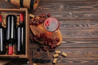 Şarap yapımı. Lezzetli şarap ve fıçıyla ahşap masa üzerinde düz kompozisyon, metin için boşluk