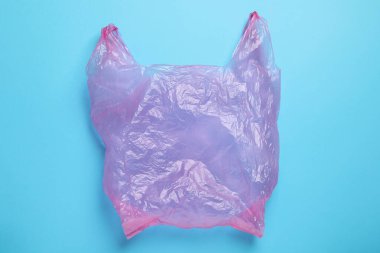 Açık mavi arka planda bir plastik torba, üst manzara.