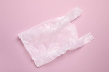 Pembe arka planda bir plastik torba, üst manzara.
