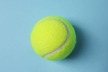 Açık mavi arka planda bir tenis topu, üst manzara.