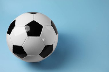 Açık mavi arka planda bir futbol topu, mesaj için boşluk. Spor malzemeleri.
