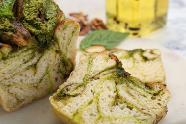 Beyaz masada taze pişmiş pesto ekmeği, yakın plan.