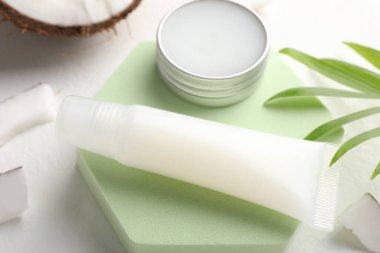 Dudak kremleri ve beyaz arkaplanda yapraklar