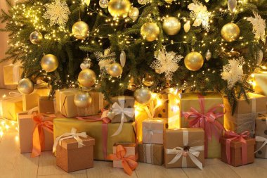 Evde birçok hediye kutusu süslenmiş Noel ağacının altında