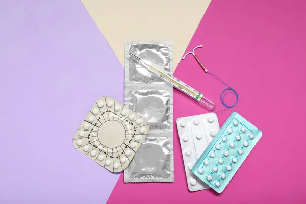 Pílulas Contraceptivas Preservativos Dispositivo Intrauterino Termômetro Fundo Colorido Flat Lay — Fotografia de Stock