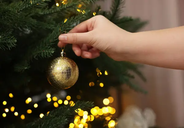 Γυναίκα Διακόσμηση Έλατο Χρυσή Χριστουγεννιάτικη Μπάλα Εσωτερικούς Χώρους Closeup — Φωτογραφία Αρχείου