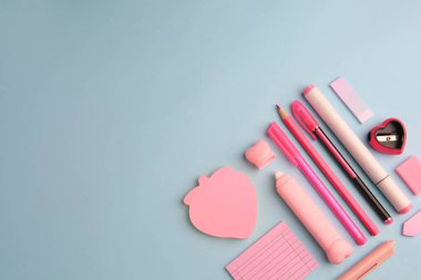 Açık mavi arkaplan üzerine yapışkan notlu düz kompozisyon ve diğer okul kırtasiyesi, metin için boşluk. Okula geri dön.