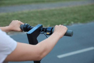 Modern elektrikli scooter 'ı olan kadın dışarıda, yakın plan.