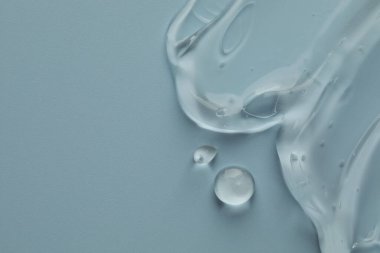 Açık mavi arka planda temiz kozmetik jel, üst manzara. Metin için boşluk