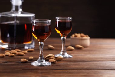 Lezzetli amaretto ile liqueur bardaklar ve ahşap masada badem, yakın plan. Metin için boşluk